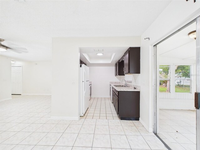 2434 Mill Run Blvd, Kissimmee, FL 34744 - kitchen featuring a sink, light tile patterned flooring, light countertops, and dark brown cabinets