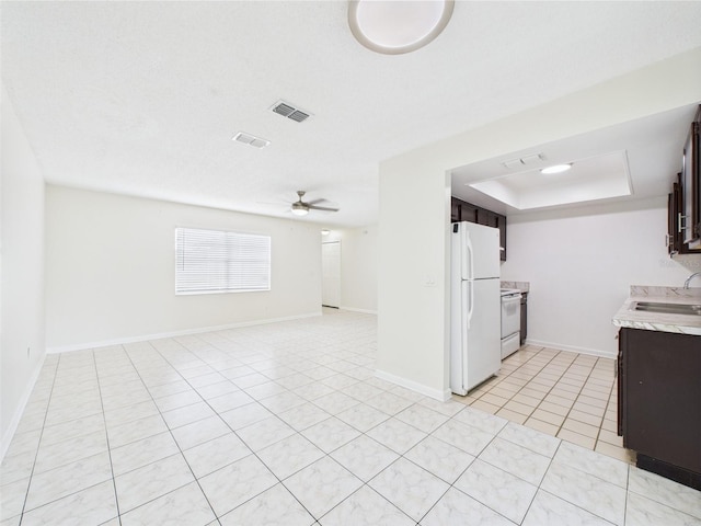 2434 Mill Run Blvd, Kissimmee, FL 34744 - kitchen featuring white appliances, dark brown cabinetry, ceiling fan, light countertops, and light tile patterned floors