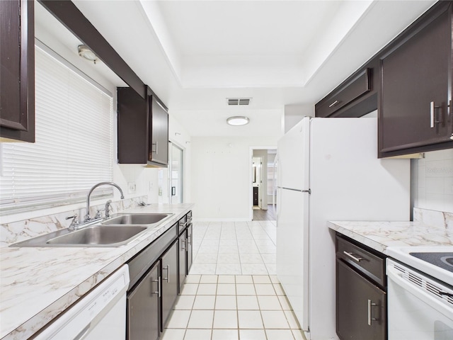 2434 Mill Run Blvd, Kissimmee, FL 34744 - kitchen featuring a tray ceiling, a sink, dark brown cabinets, and visible vents