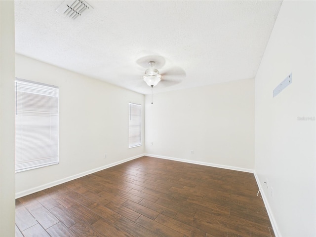 2434 Mill Run Blvd, Kissimmee, FL 34744 - spare room with a ceiling fan, dark wood finished floors, visible vents, baseboards, and a textured ceiling