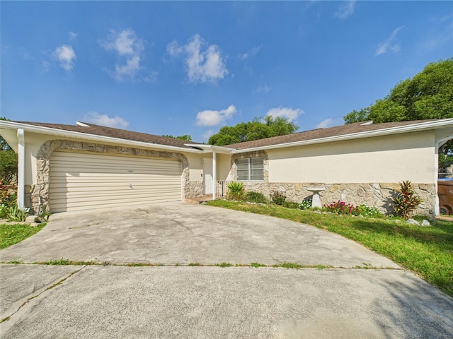 2434 Mill Run Blvd, Kissimmee, FL 34744 - view of front of house with concrete driveway, a garage, stucco siding, and stone siding