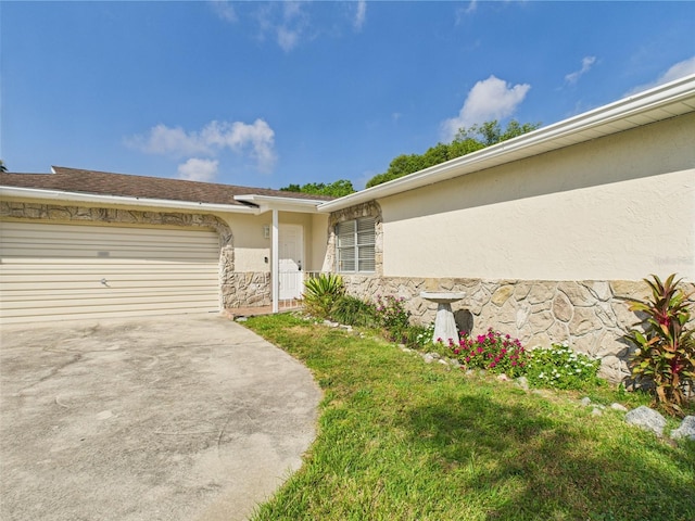 2434 Mill Run Blvd, Kissimmee, FL 34744 - entrance to property with concrete driveway, an attached garage, stucco siding, and stone siding