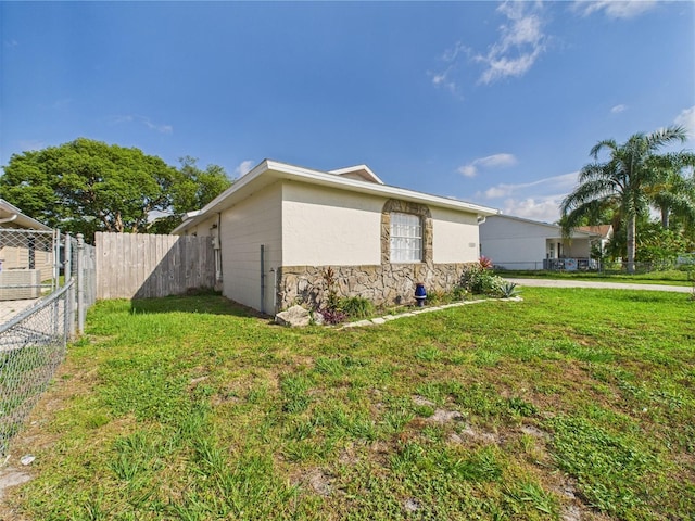 2434 Mill Run Blvd, Kissimmee, FL 34744 - view of side of property featuring a yard, fence, and stone siding