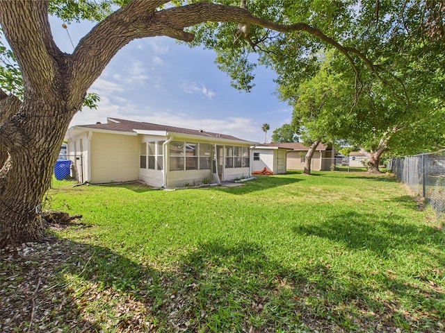 2434 Mill Run Blvd, Kissimmee, FL 34744 - back of property with a fenced backyard, a sunroom, and a lawn