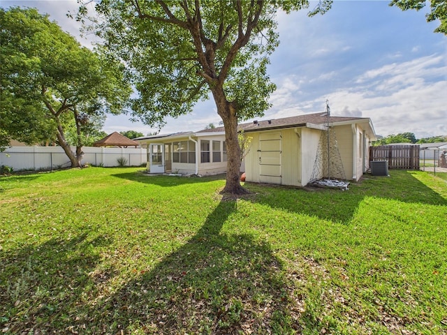 2434 Mill Run Blvd, Kissimmee, FL 34744 - back of house with a sunroom, a yard, a fenced backyard, and central AC