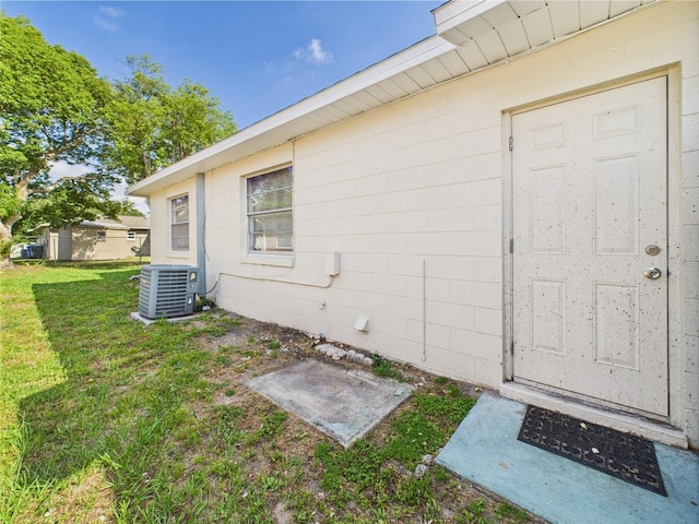 2434 Mill Run Blvd, Kissimmee, FL 34744 - entrance to property featuring a yard, central AC unit, and concrete block siding