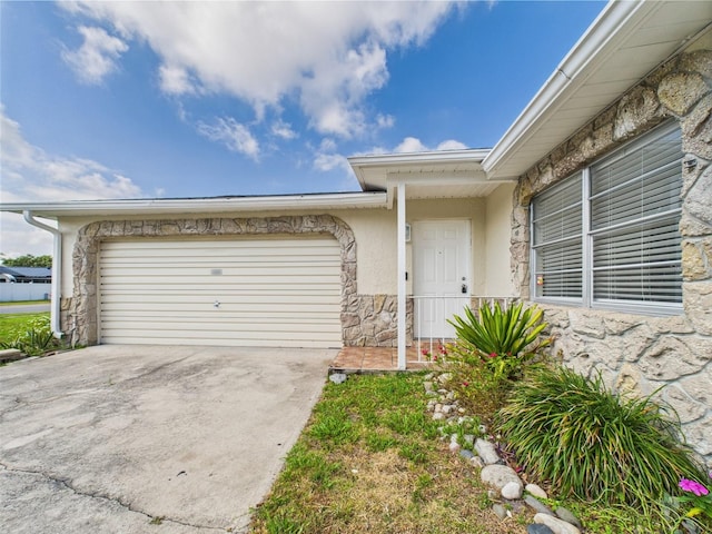 2434 Mill Run Blvd, Kissimmee, FL 34744 - entrance to property with a garage, stucco siding, stone siding, and driveway