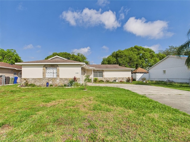 2434 Mill Run Blvd, Kissimmee, FL 34744 - single story home with fence, stone siding, driveway, stucco siding, and a front yard
