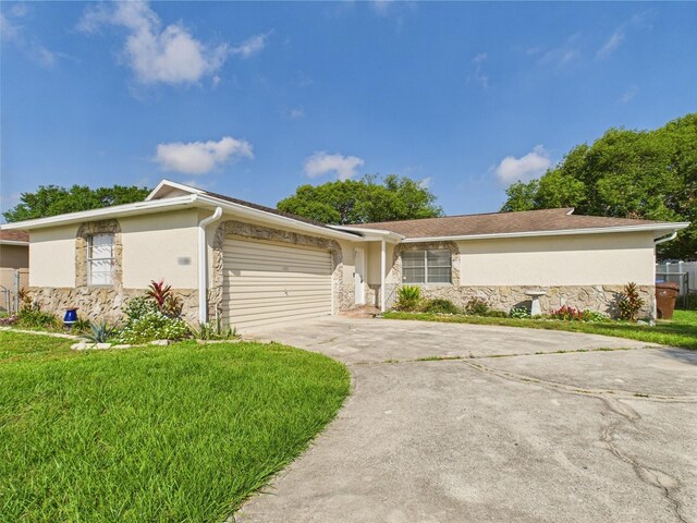 2434 Mill Run Blvd, Kissimmee, FL 34744 - ranch-style house with concrete driveway, stone siding, stucco siding, and a front yard