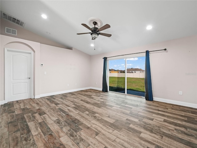 spare room with hardwood / wood-style floors, vaulted ceiling, and ceiling fan