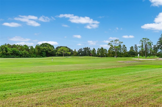 view of property's community featuring golf course view and a lawn