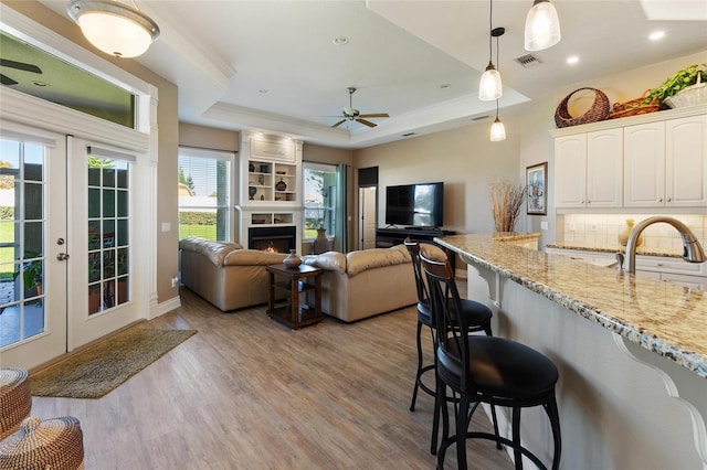 kitchen with pendant lighting, open floor plan, white cabinetry, and a breakfast bar area