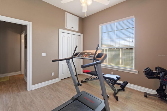 exercise area with light wood-type flooring, ceiling fan, and baseboards