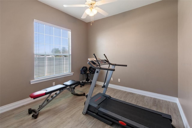 workout room with ceiling fan, light wood-style flooring, and baseboards