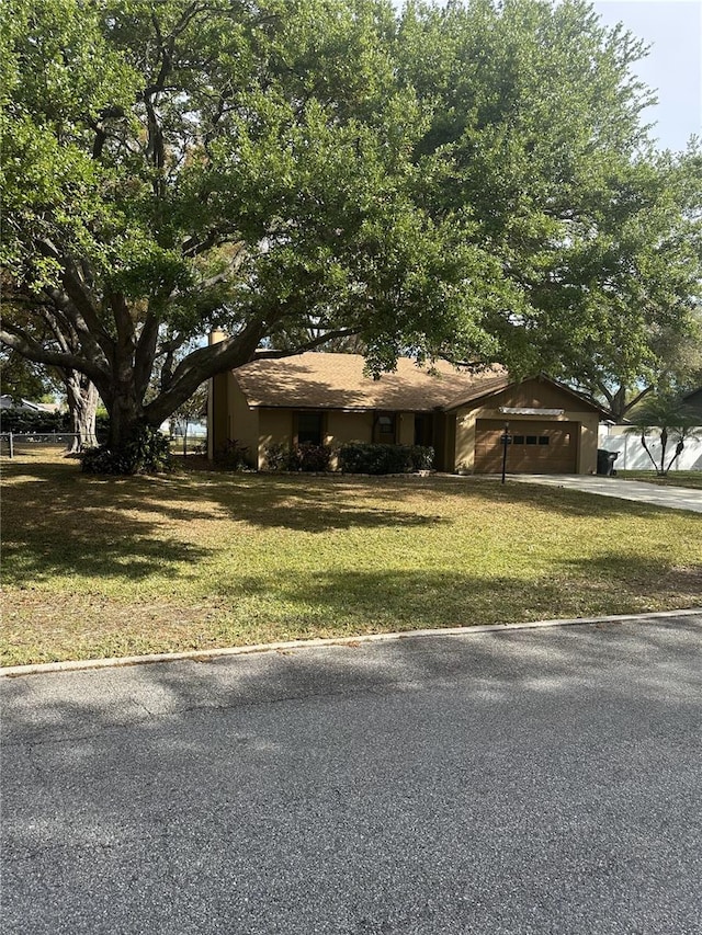 view of front facade with a garage, driveway, and a front lawn