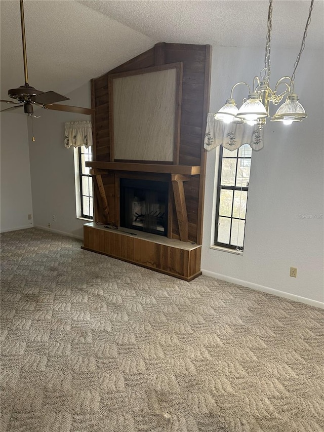 unfurnished living room featuring a large fireplace, carpet flooring, vaulted ceiling, a textured ceiling, and baseboards