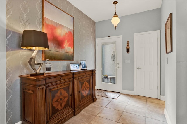 foyer entrance with light tile patterned floors and baseboards