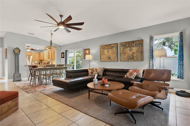 living room with vaulted ceiling, ceiling fan with notable chandelier, and light tile patterned flooring