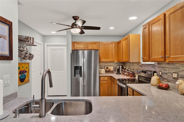 kitchen with ceiling fan, stainless steel appliances, tasteful backsplash, and a sink