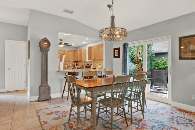 dining area featuring baseboards, visible vents, lofted ceiling, light tile patterned flooring, and ceiling fan with notable chandelier