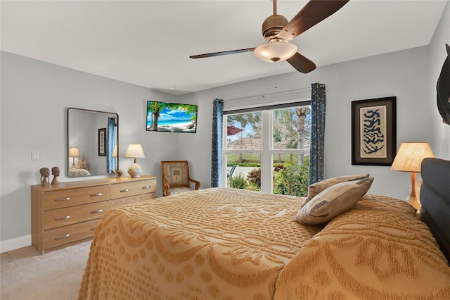 bedroom featuring light carpet, baseboards, and a ceiling fan