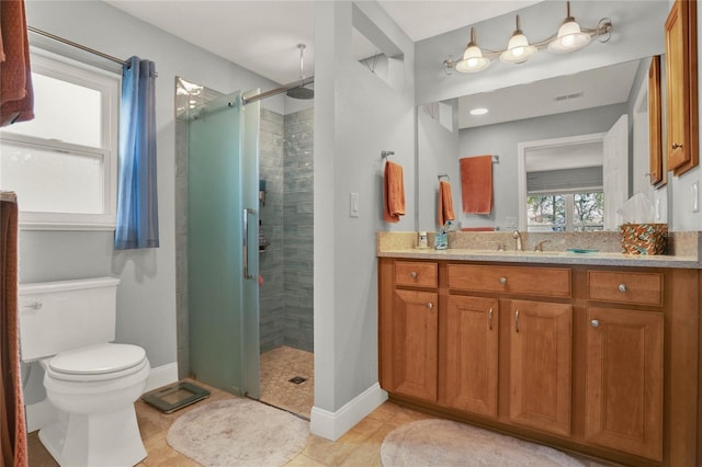 bathroom featuring visible vents, vanity, a shower stall, baseboards, and tile patterned floors