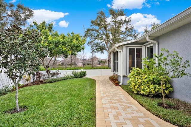 view of yard featuring a sunroom and fence