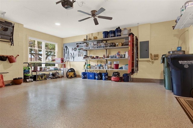 garage featuring a garage door opener, concrete block wall, electric panel, and ceiling fan