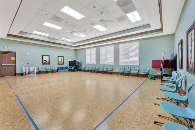 interior space with a paneled ceiling, ceiling fan, baseboards, and a raised ceiling