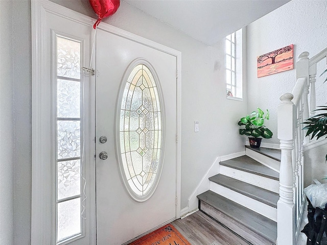 foyer featuring stairs and wood finished floors