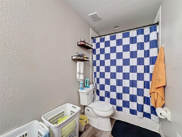 full bathroom with a textured ceiling, a textured wall, visible vents, and a shower with curtain