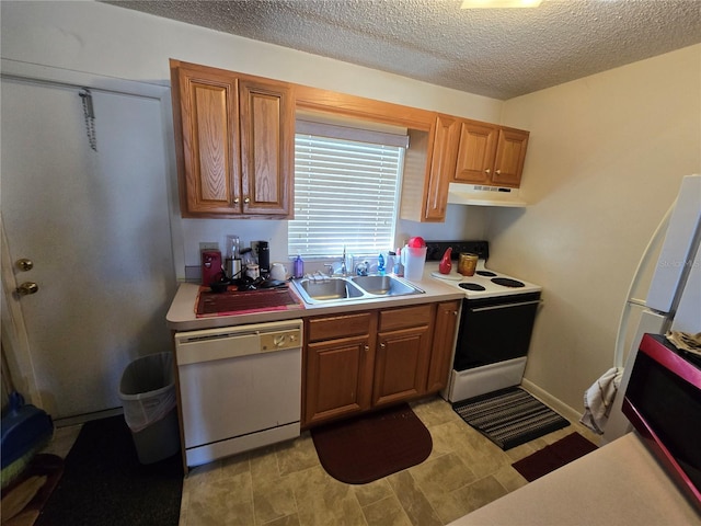 kitchen featuring under cabinet range hood, white appliances, a sink, light countertops, and brown cabinetry