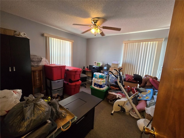 game room with ceiling fan, carpet floors, and a textured ceiling