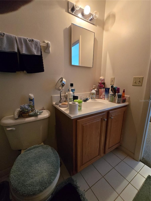 half bath with vanity, toilet, and tile patterned floors