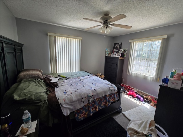 bedroom with carpet flooring, ceiling fan, and a textured ceiling