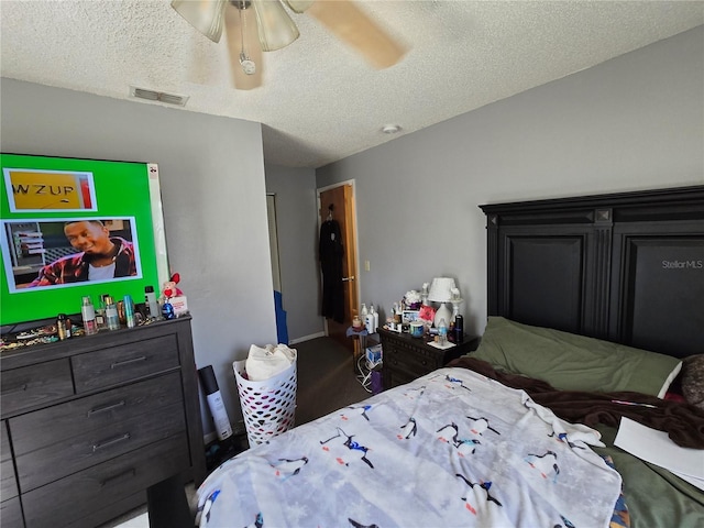 bedroom with a ceiling fan, visible vents, and a textured ceiling