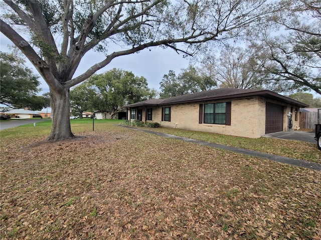 exterior space featuring a garage, a lawn, and brick siding