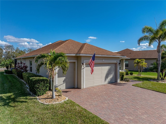 ranch-style house with an attached garage, a front lawn, decorative driveway, and stucco siding