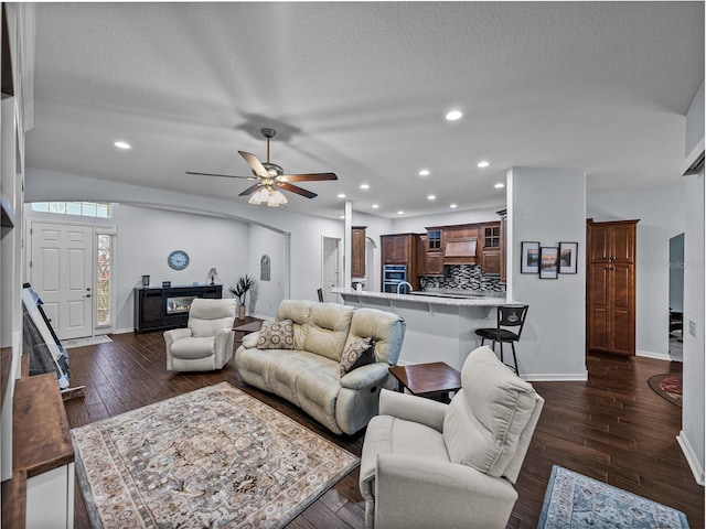 living area featuring ceiling fan, dark wood-style flooring, recessed lighting, and baseboards