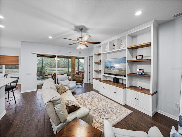 living area featuring dark wood-style floors, baseboards, visible vents, and ceiling fan