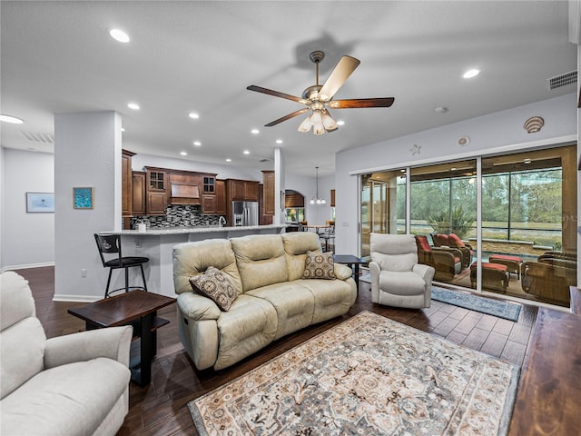 living room with dark wood-type flooring, visible vents, and recessed lighting