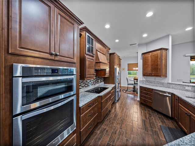 kitchen with light stone counters, dark wood-style floors, custom exhaust hood, stainless steel appliances, and recessed lighting