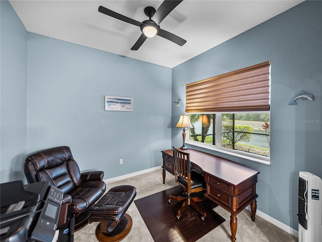 office space featuring a ceiling fan, carpet flooring, and baseboards