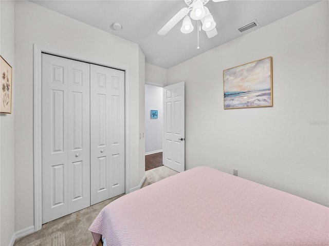 bedroom featuring a closet, visible vents, light carpet, ceiling fan, and baseboards