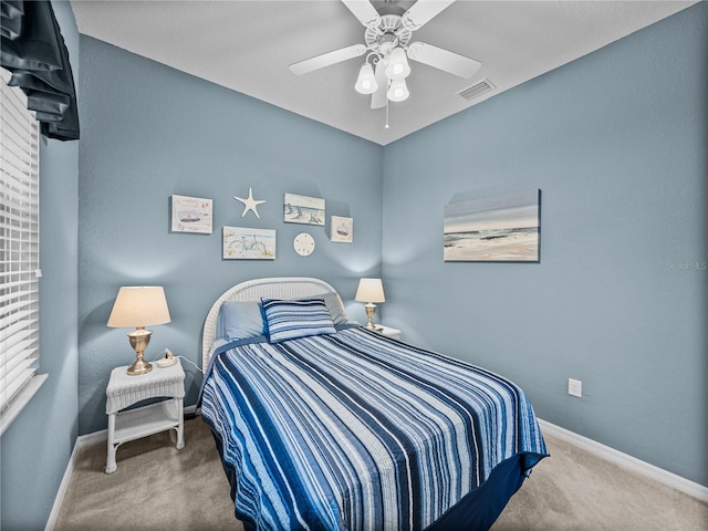 carpeted bedroom with baseboards, visible vents, and ceiling fan