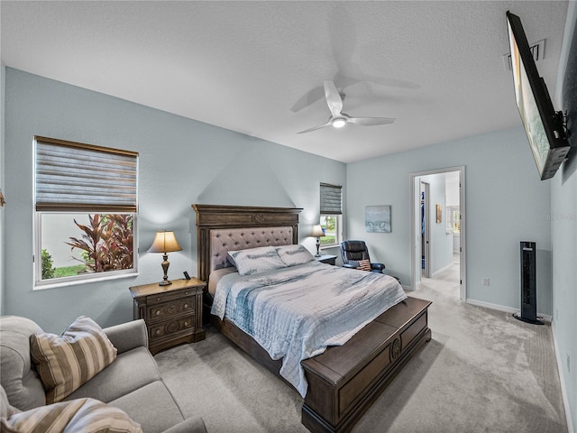 bedroom with carpet floors, multiple windows, a textured ceiling, and baseboards