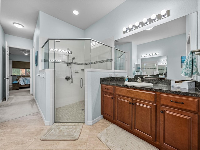 ensuite bathroom with ensuite bathroom, vanity, baseboards, tile patterned floors, and a stall shower