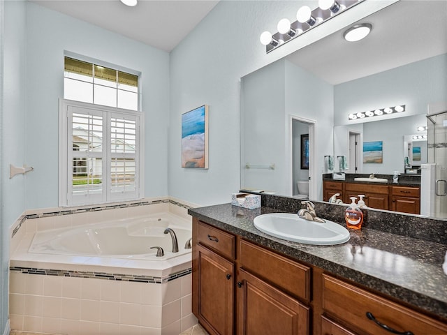 bathroom with two vanities, toilet, a sink, a shower stall, and a bath