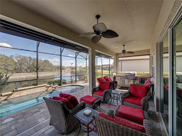 sunroom / solarium with a ceiling fan and a water view