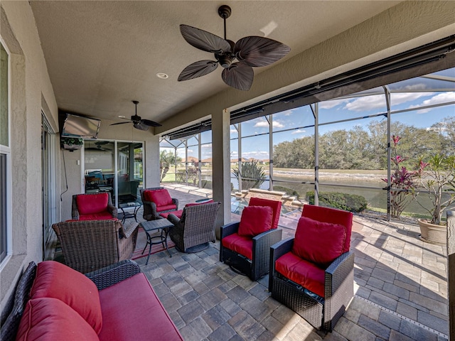 view of patio / terrace featuring glass enclosure, ceiling fan, and outdoor lounge area